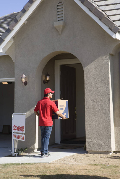 Delivery man holding Cardboard box - Фото, изображение