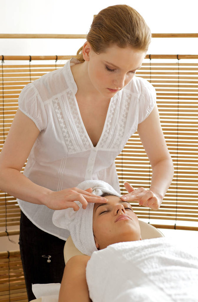 Young woman receiving head massage from masseuse - Fotografie, Obrázek