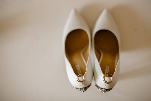 Wedding white shoes. Wedding ring - Фото, изображение