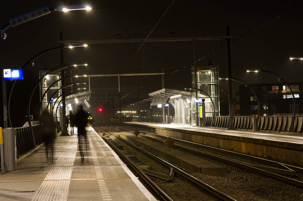People blurred by motion at station Arnhem south at night - Fotoğraf, Görsel