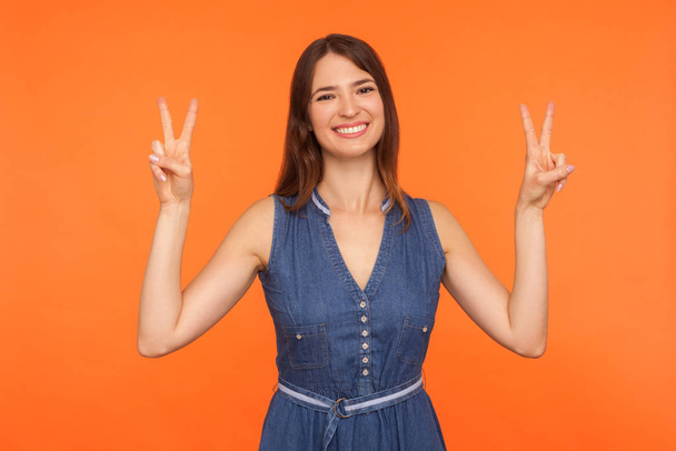Peace and victory to you! Friendly cheerful brunette woman in de - Fotografie, Obrázek