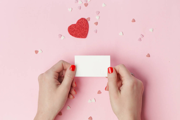 Top view of female holding blank card on pink background, Valentine 's day, Mother' s day, holiday concept
 - Фото, изображение