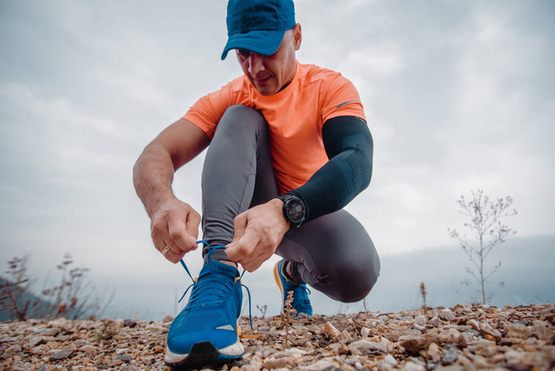 Fit μυώδης άνθρωπος φορώντας ρούχα γυμναστικής προετοιμασία για ένα τρέξιμο - Φωτογραφία, εικόνα