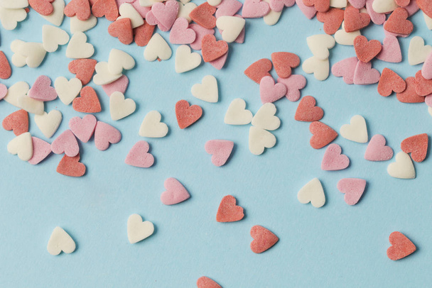 Pastel pink and white hearts on the blue background. Valentine's day, mother's day, birthday, holiday background. - Фото, зображення