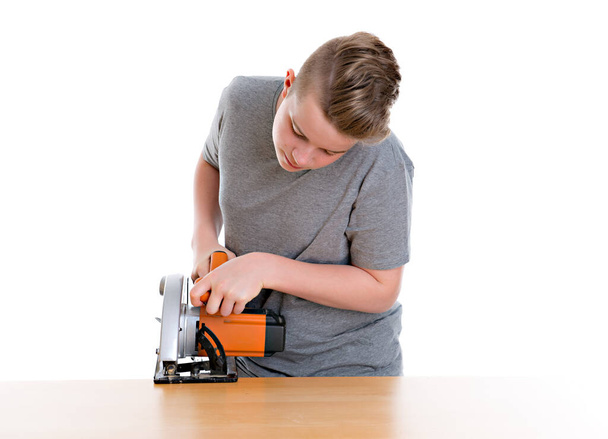teenager in professional training using circular hand saw  in front of white background - Foto, imagen