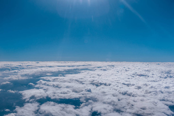 Rayons solaires qui brillent au-dessus d'une couche de nuages vus d'en haut - Photo, image