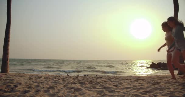 Slow motion: Vrouwen vrienden hardlopen genieten van het leven spelen en vrijheid strand bij zonsondergang, Aantrekkelijk samen van Aziatische vrouwelijke reiziger met vrienden mensen levensstijl. 4k Uhd. - Video