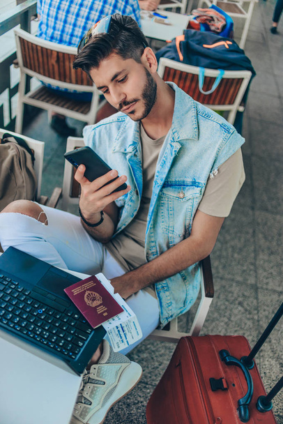 Hombre en la sala de negocios del aeropuerto esperando el vuelo mientras usa el teléfono móvil
 - Foto, imagen