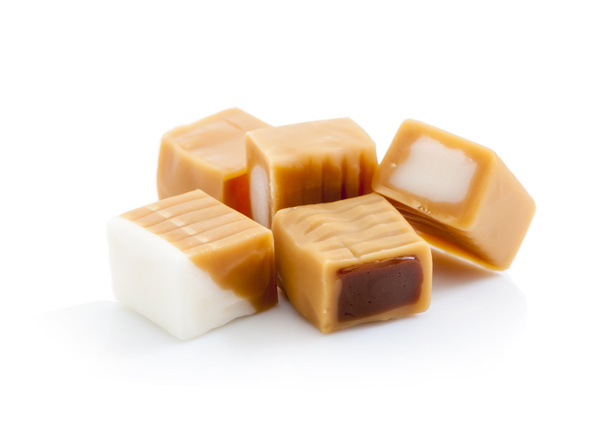 Cukierki karmelowe z nadzieniem czekoladowym i krem na białym tle - Zdjęcie, obraz