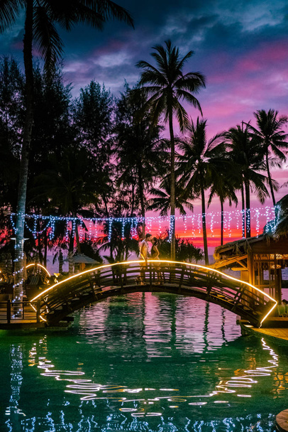 Paar beobachtet Sonnenuntergang am Strand und Pool eines Luxus-Resorts in Thailand khao lak - Foto, Bild