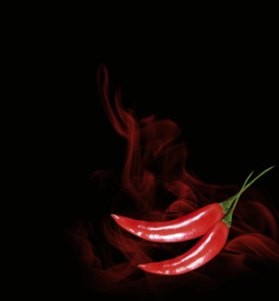 humo de pimiento rojo sobre un fondo de chile negro
 - Foto, imagen