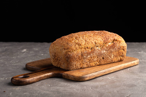 A traditional square loaf of bread. One whole fresh baked bread on stone table. Fresh homemade baked bread - 写真・画像