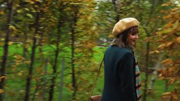 Joyful girl in elegant outfit walking in garden maze in autumn - Filmati, video