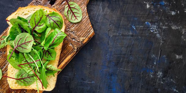 Сэндвич листья смеси салат микрозеленый (вкусные закуски, вегетарианские) концепции меню. Предыстория. вид сверху. сохранить копию
 - Фото, изображение