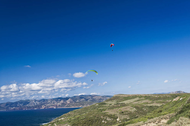 Colorful hang glider in sky over blue sea - Photo, Image