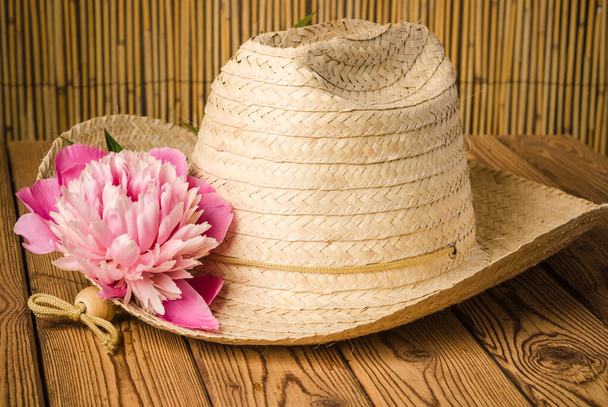Straw hat and peony flower, close-up - 写真・画像