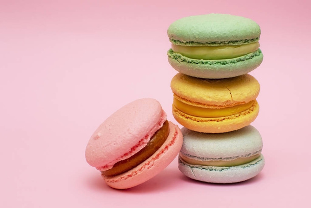 Fresh vibrant colored macarons, or macaroons on a pink background with copy space - Photo, Image