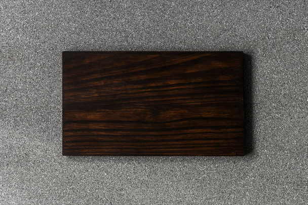 Background of grey stone texture and pattern with brown wooden cutting board. - Photo, Image