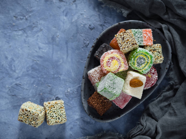 turkish delight with pistachios and pistachio nuts on a dark background - Фото, изображение