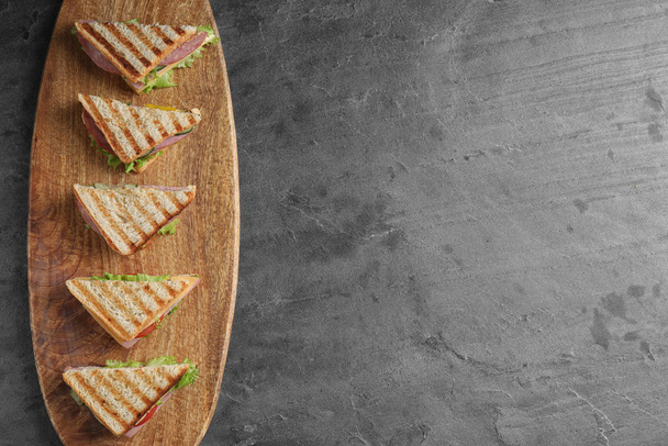 Tasty sandwiches with ham on grey table, top view. Space for text - Photo, Image