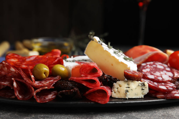 Tasty salami and other delicacies served on grey table, closeup - Photo, Image