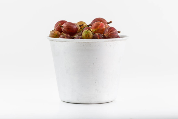 Bunch of gooseberries stacked in a old alluminum pot - Fotoğraf, Görsel