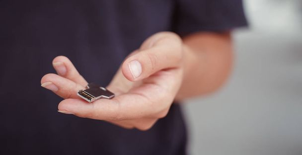 usb stick in the form of a key in the hand of a woman. - 写真・画像