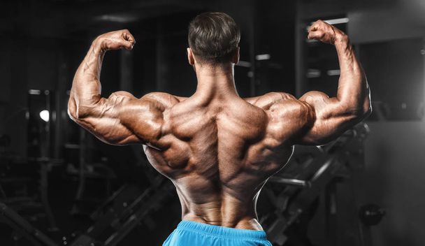 Bodybuilder strong man pumping up biceps muscles - Фото, зображення