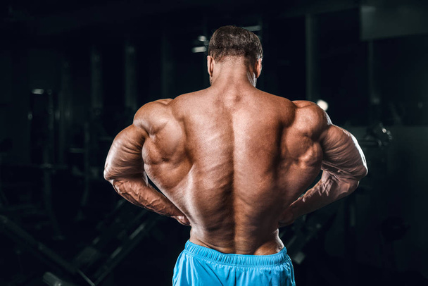 Bodybuilder strong man pumping up biceps muscles - Фото, зображення