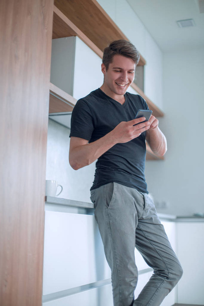 smiling casual man looking at the screen of his smartphone - Foto, imagen