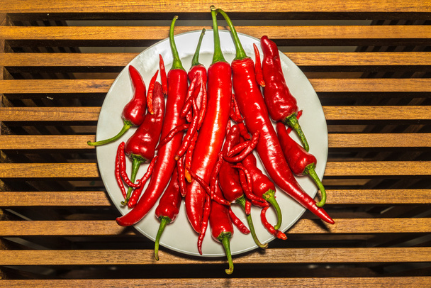 Group of hot spicy chilli peppers on a white plate - Photo, Image