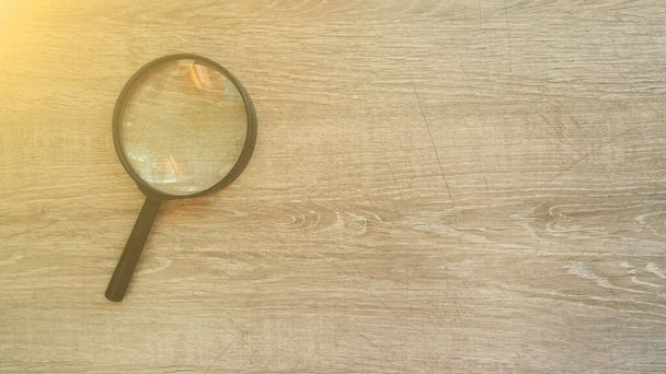 magnifying glass on the grey laminate background. Sun effect. - 写真・画像