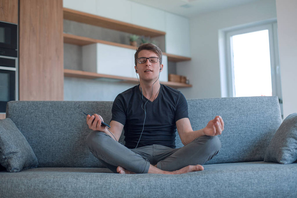 man relaxing to his favorite music, sitting in the Lotus position - Foto, imagen