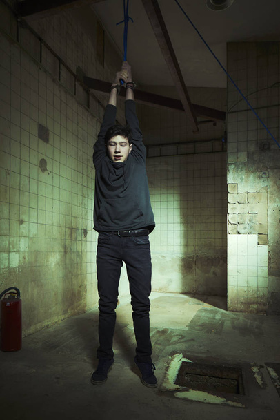 Violent kidnapper have bonded hanging young man under control - Fotoğraf, Görsel