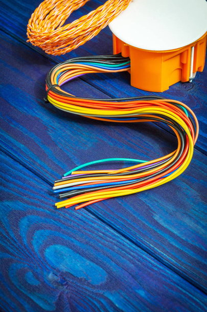 Skrzynka przyłączeniowa elektryczna pomarańczowa z przewodami zwykle używanymi w procesie instalacji elektrycznej - Zdjęcie, obraz