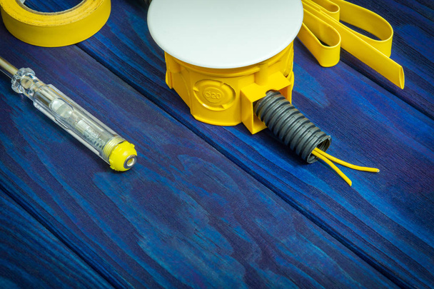 Scatola gialla di giunzione elettrica con fili e utensile solitamente utilizzati nel processo di installazione elettrica
 - Foto, immagini