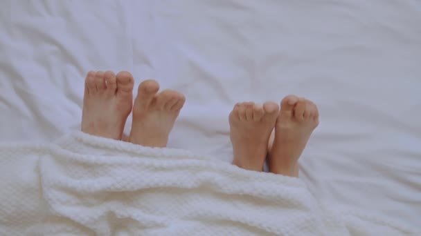 zbliżenie kobieta i mężczyzna nogi w sypialni - Materiał filmowy, wideo