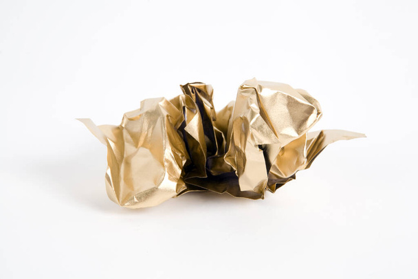 a ball of crumpled paper painted in gold. Minimal color still life and quirky photography - Photo, image