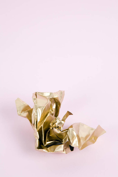 a ball of crumpled paper painted in gold. Minimal color still life and quirky photography - Zdjęcie, obraz