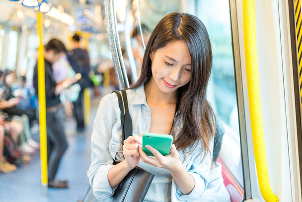 Woman use of cellphone inside train compartment - Fotoğraf, Görsel