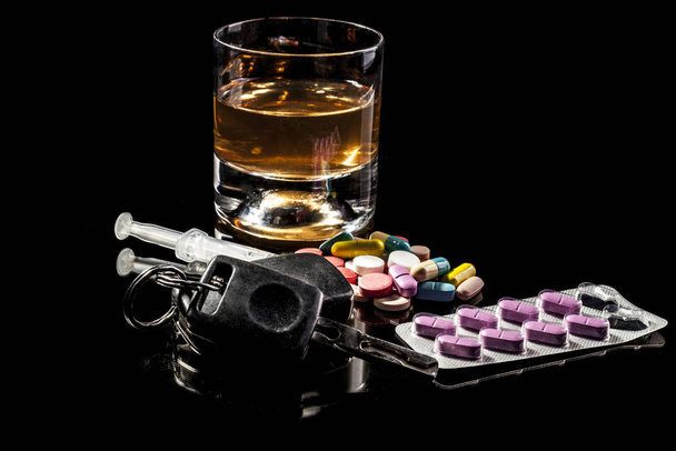 Alchohol,pills and car keys isolated on black background with reflection - 写真・画像