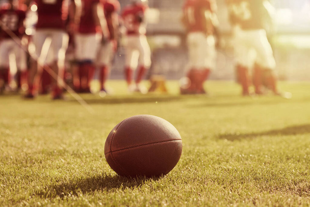 Close up of an american football on the field in the sunshine - Foto, Imagem