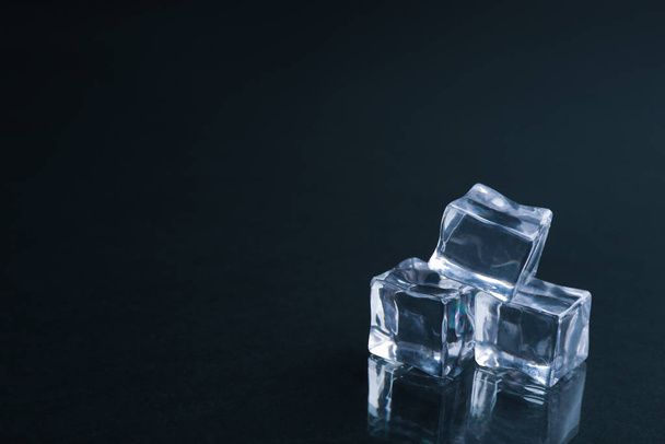Crystal clear ice cubes on black background. Space for text - Foto, afbeelding
