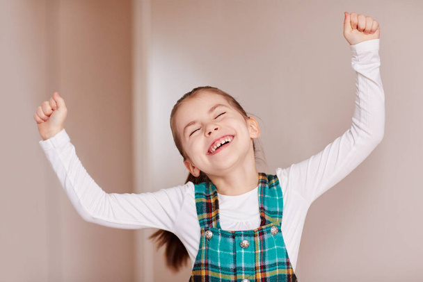 A cute little girl throwing her hands in the air. - 写真・画像