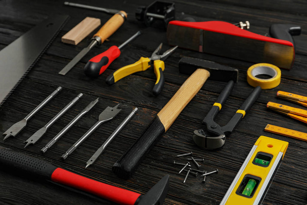 Different carpenter's tools on black wooden background - Fotoğraf, Görsel