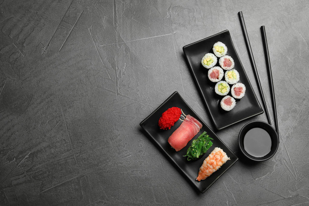 Set of delicious sushi and rolls on grey table, flat lay. Space for text - Φωτογραφία, εικόνα