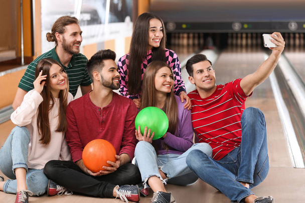 Group of friends taking selfie in bowling club - Фото, изображение