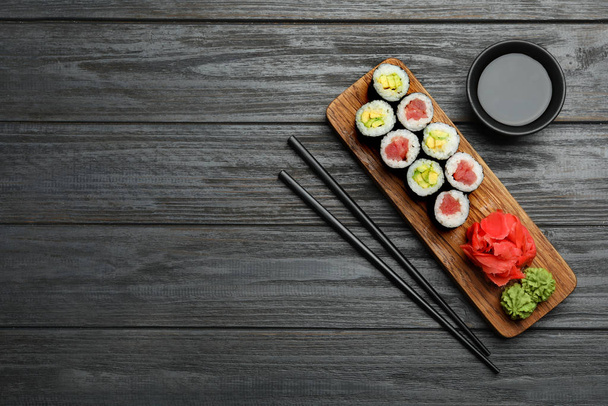 Delicious sushi rolls on grey wooden table, flat lay. Space for text - Foto, imagen