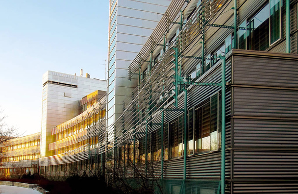 Curved modern building with glass and metal facade. - Zdjęcie, obraz