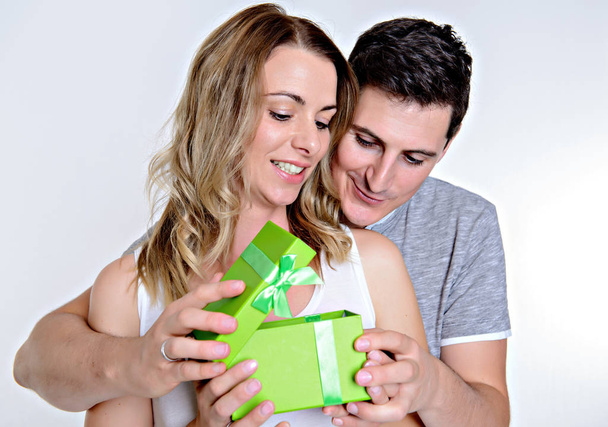 young beautiful couple with gift box in front of white background - Photo, image